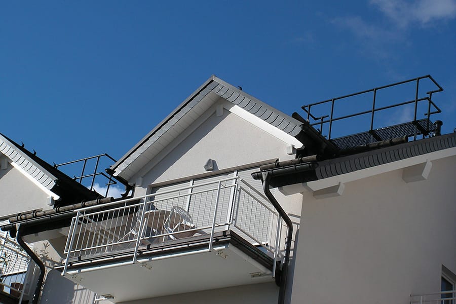 Laufroste mit Geländer neben einem Giebel-Balkon