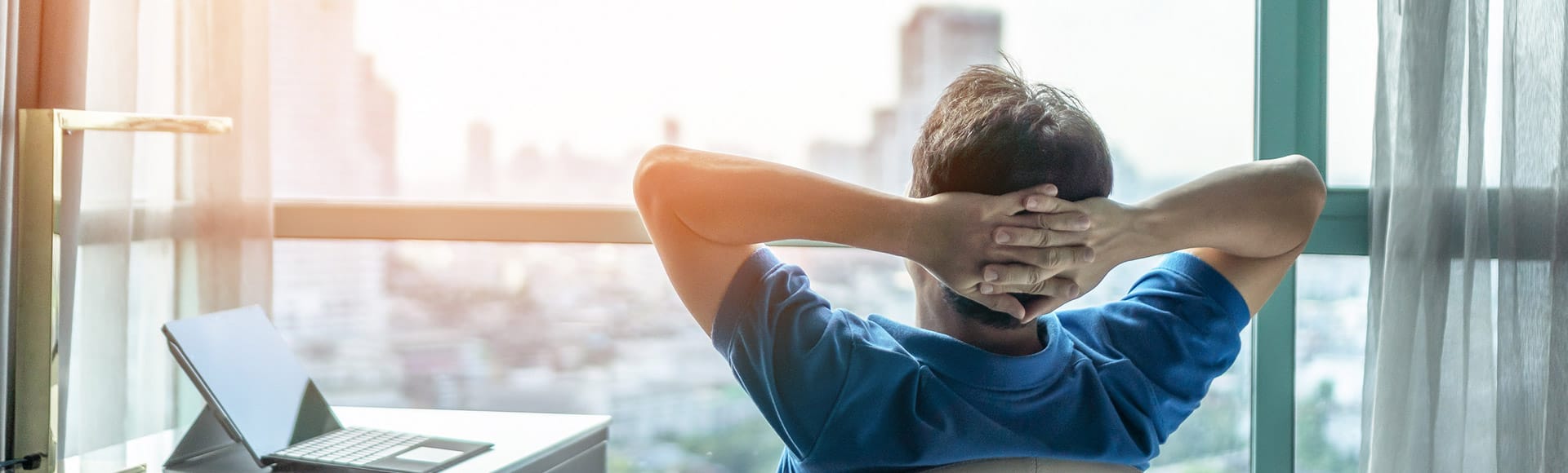 Ein Mann schaut aus seinem Fenster auf eine Großstadt mit Wolkenkratzern