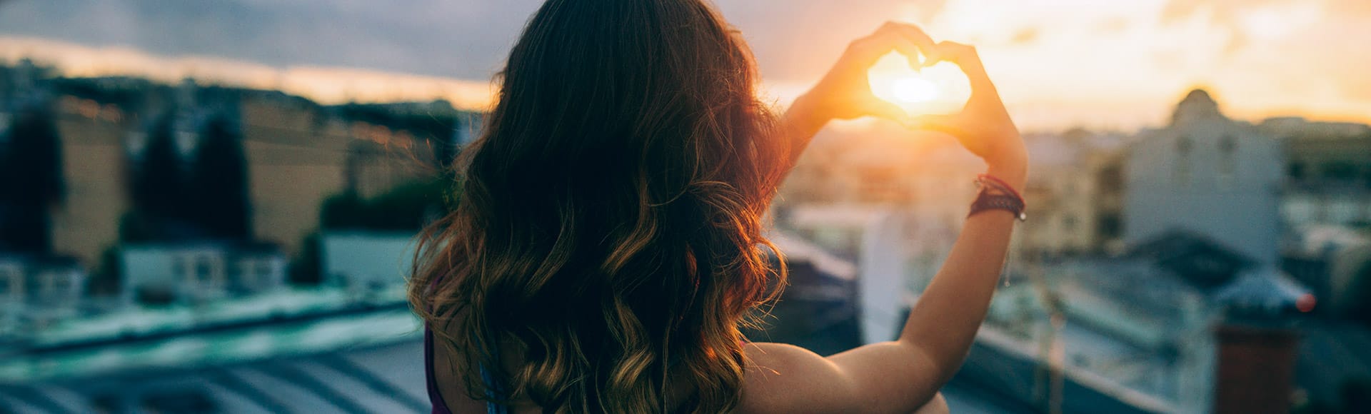 Eine Frau formt mit ihren Fingern ein Herz 